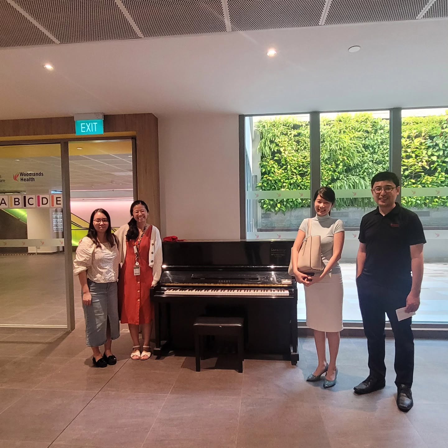 Iconomy Foundation representatives and partners with a public piano at Woodlands Health Campus
