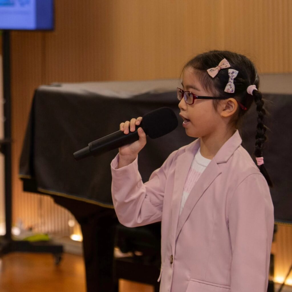 Young participant speaking into a microphone at an Iconomy Foundation event