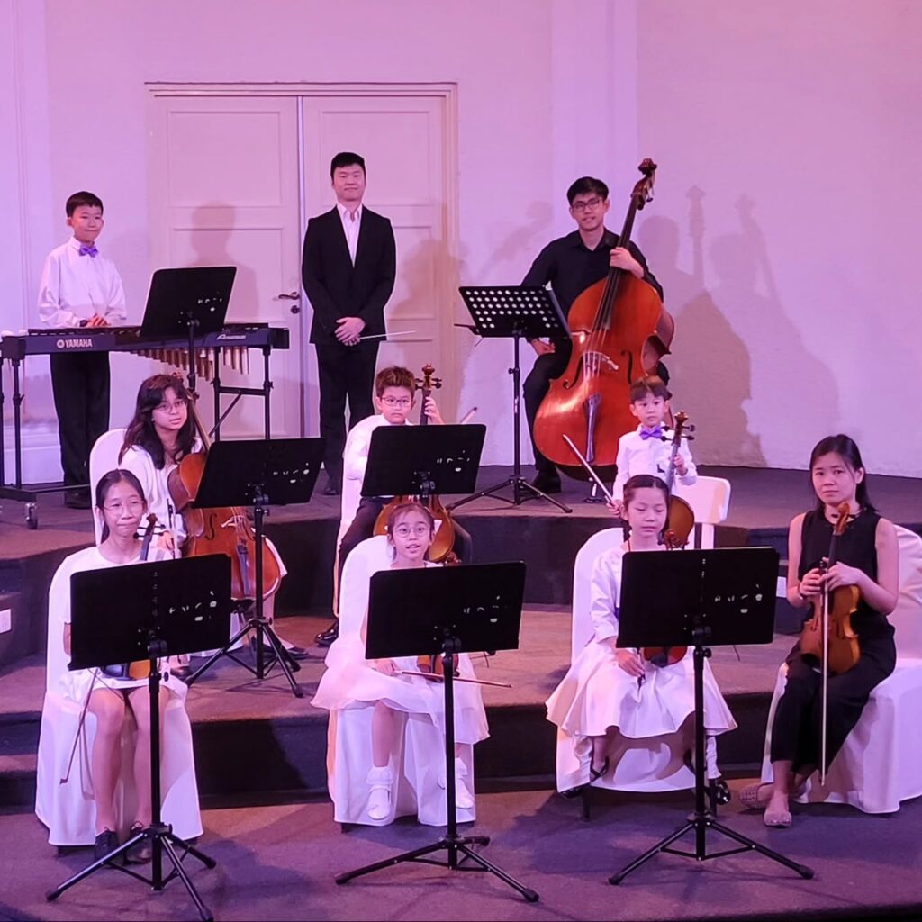 Children and youth musicians performing together on stage